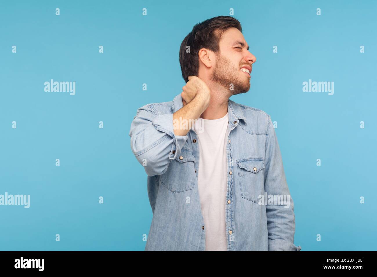 https://c8.alamy.com/comp/2BXFJBE/portrait-of-exhausted-young-man-in-denim-shirt-touching-neck-and-grimacing-from-intense-pain-massaging-to-relieve-muscle-tension-hurting-shoulders-2BXFJBE.jpg