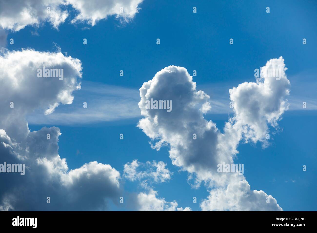 Grayish white clouds on blue sky , rising on updraft , Finland Stock Photo