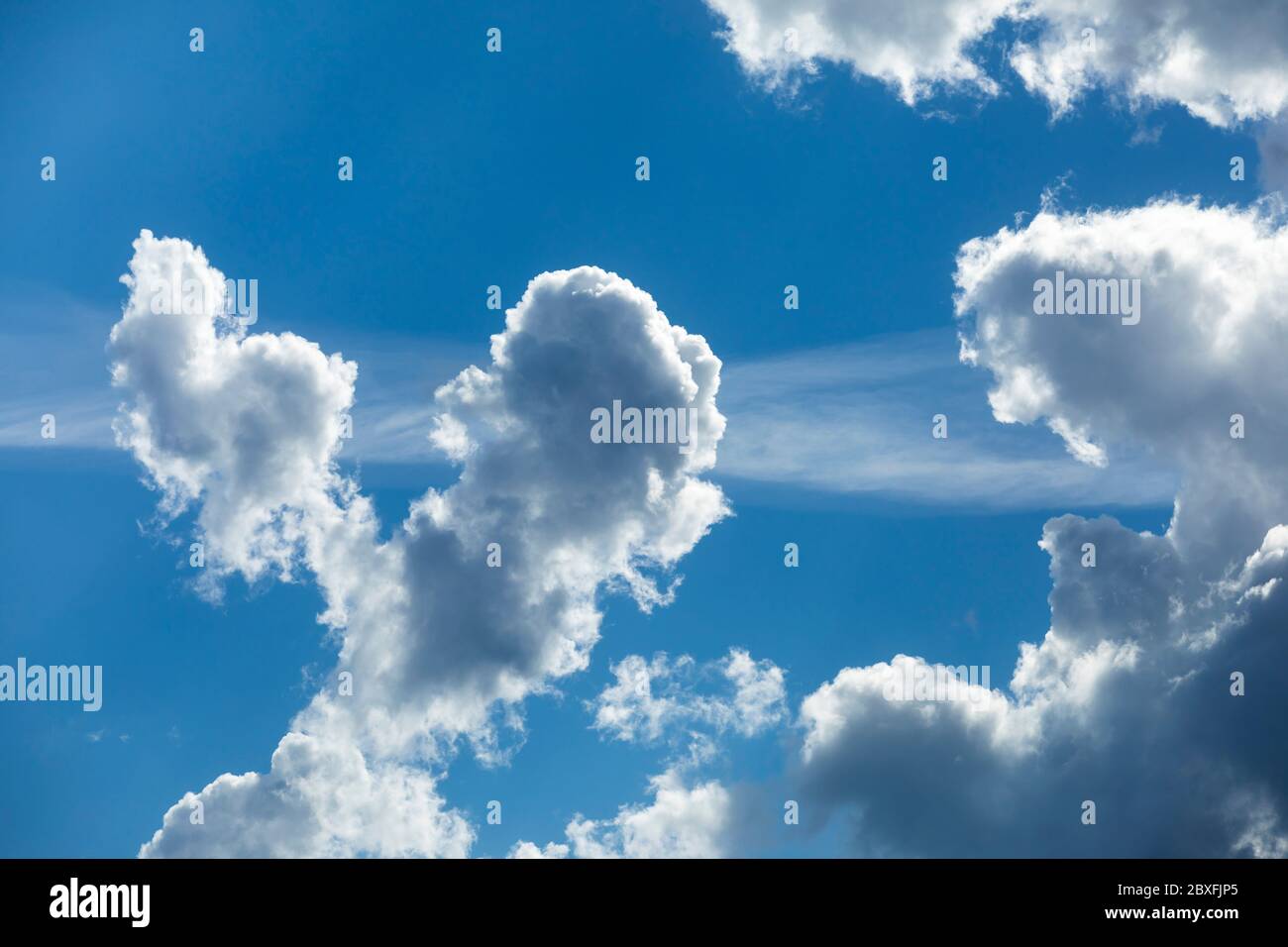 Grayish white clouds on blue sky , rising on updraft , Finland Stock Photo