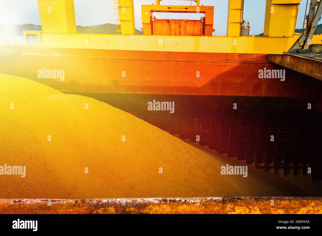 Raw sugar bulk inside large vessel after completed load ready for draft survey. Sugar bulk products transport and handling. Agro-industry concept. Stock Photo