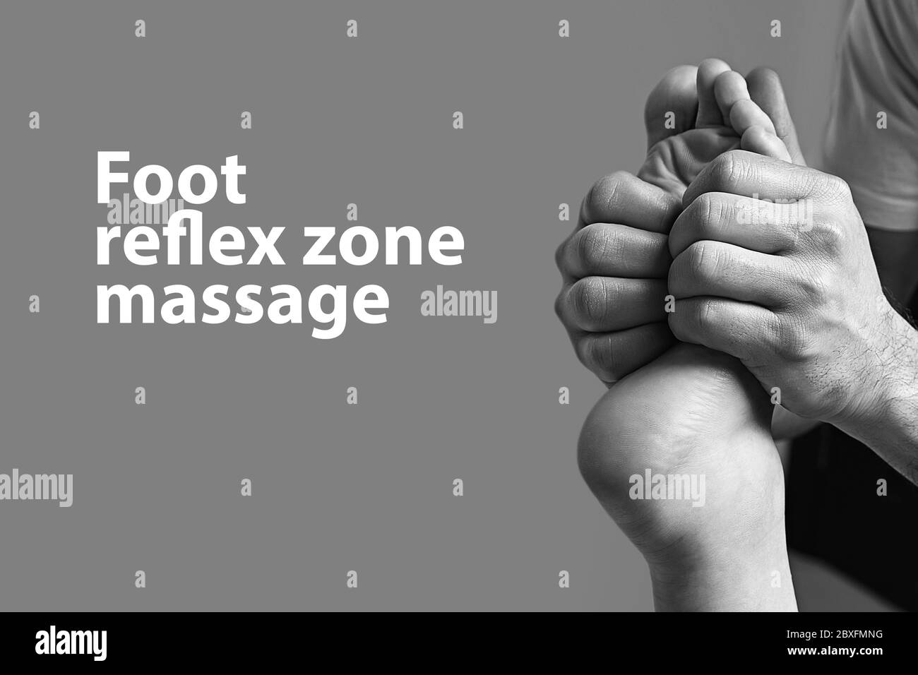 Male masseur doing massage on female foot reflex zone in the spa salon. Copy space with sample text on light grey background. Stock Photo
