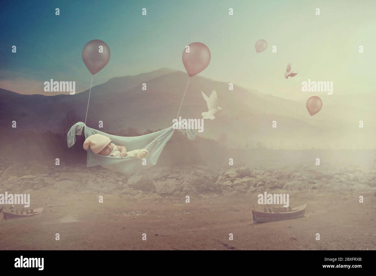 Adorable baby flying with balloons in a valley  - Dreaming Stock Photo