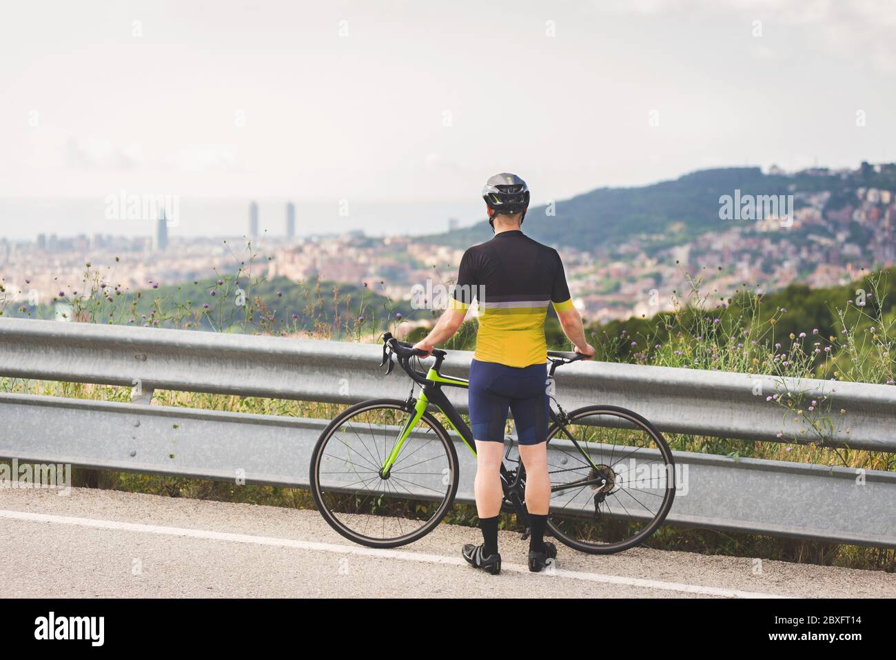 Professional cyclist looking at the city Stock Photo