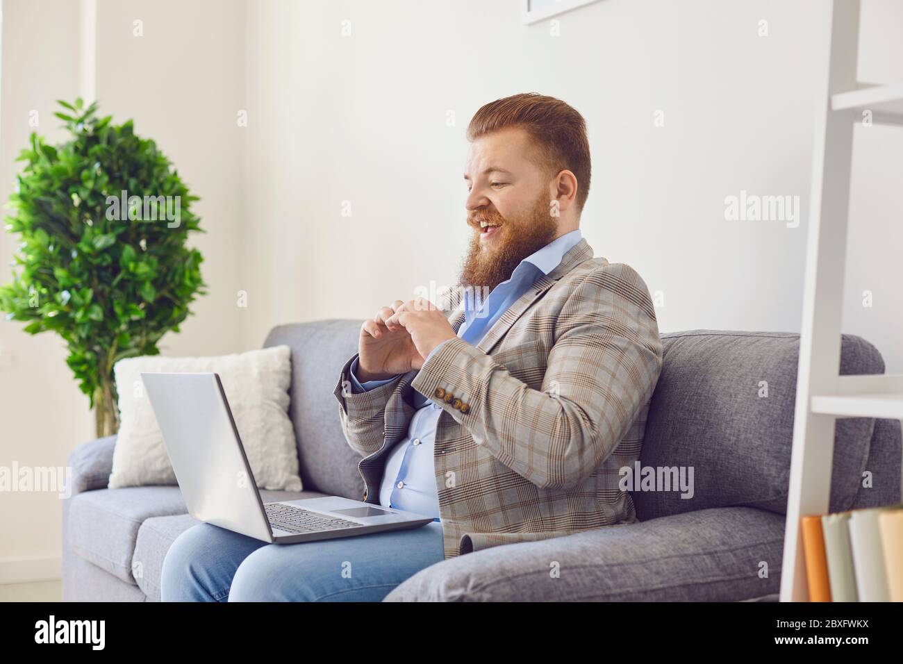 Video chat online. Delighted man talking on video chat via laptop at home Stock Photo