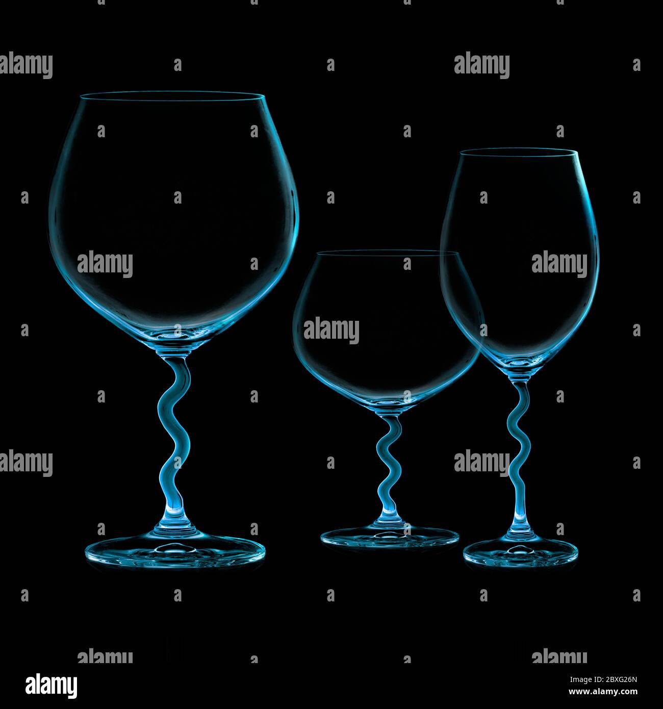 Closeup of three empty cups isolated on black. Balloon glass for red wine. Cup for white wine. Brandy glass Stock Photo