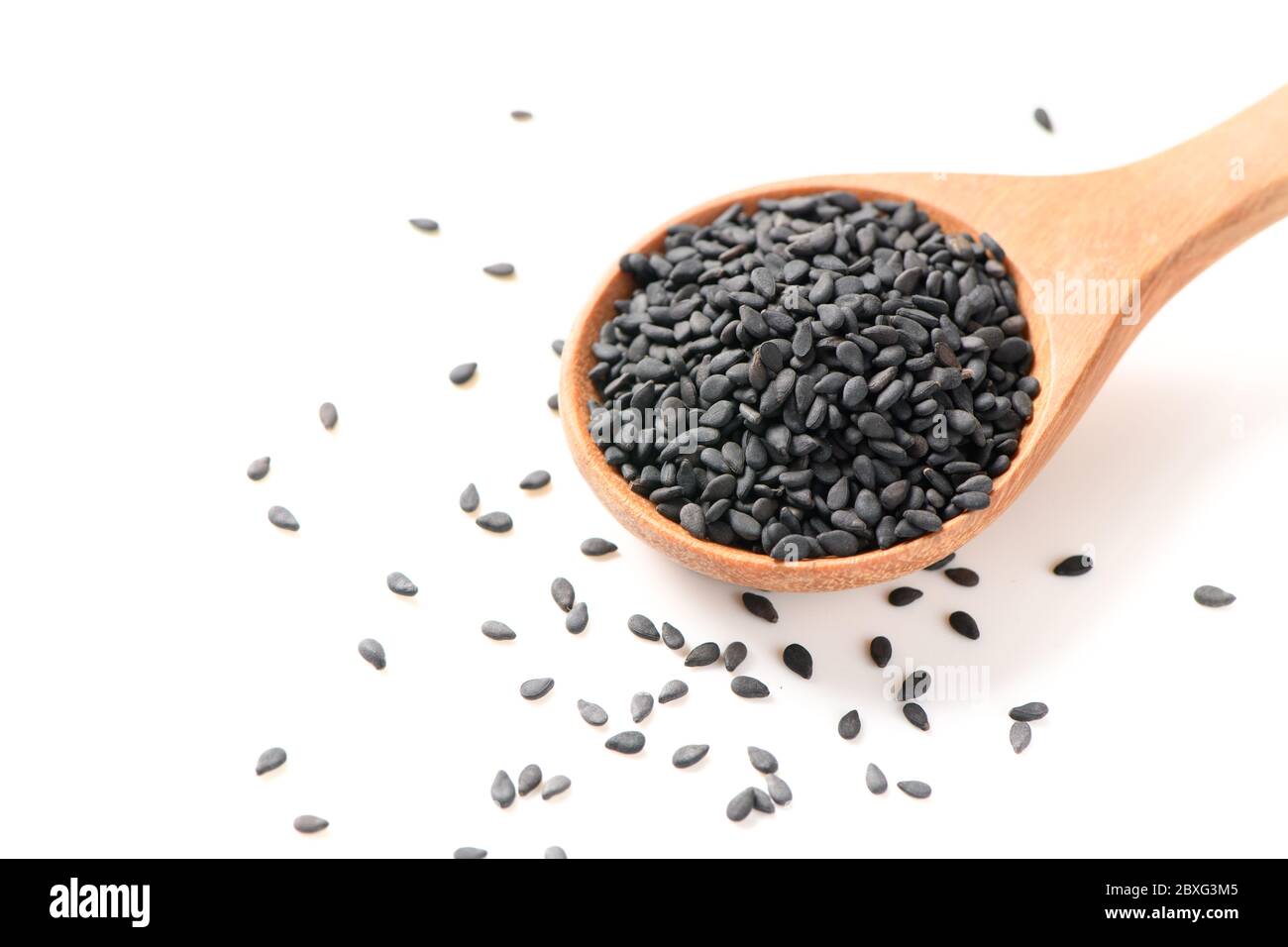 Black sesame seeds on wood spoon isolated on white background. The