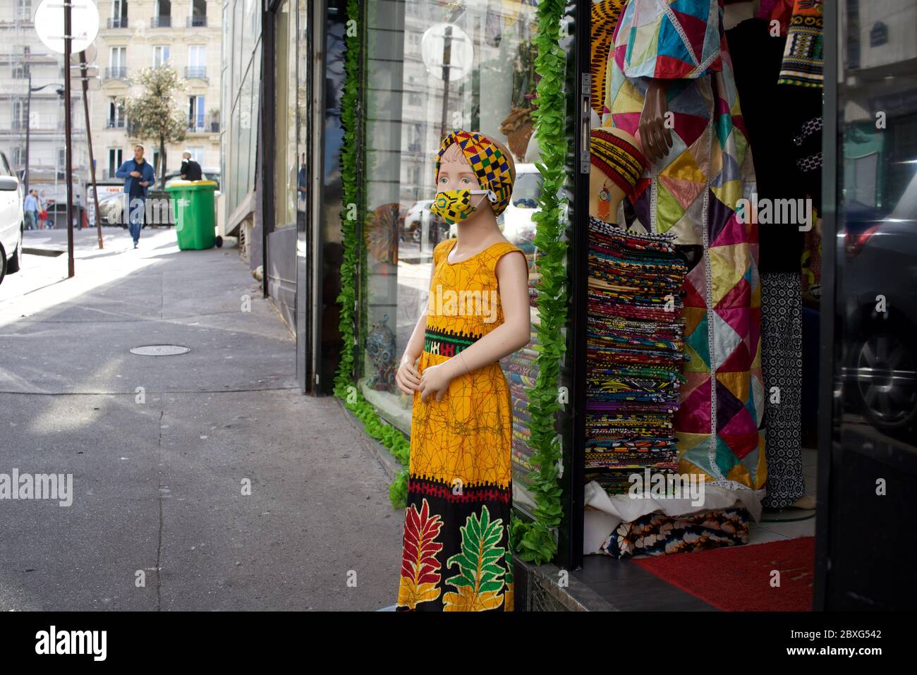 Child shop mannequin wearing face mask, African (Senegalese) fabric shop - Rue Myrha, 75018 Paris France Stock Photo