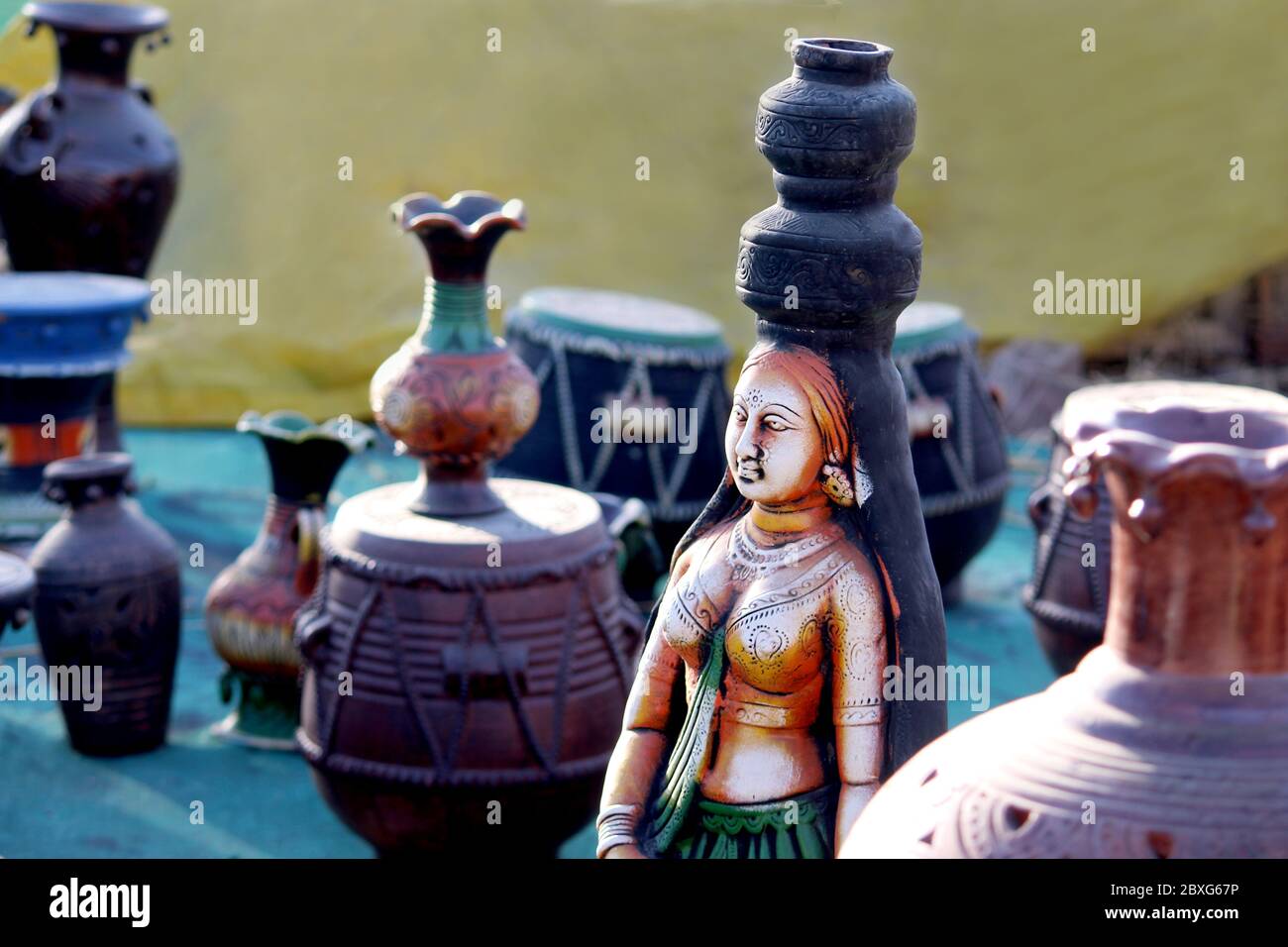 decorative village women carring pot Sculpture Made with Earthen Mud, handcrafted traditional clay decoration toy in indian market Stock Photo