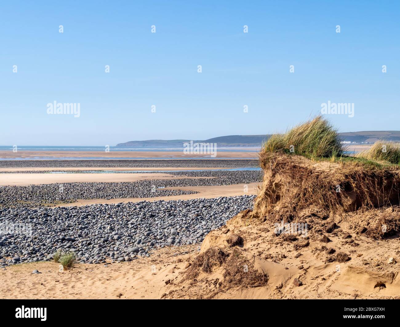 View of Northam Burrows on the Torridge and Taw estuary. Visible sand dunes and pebbles on sandy beach. Tide out. Dramatic landscape. Stock Photo