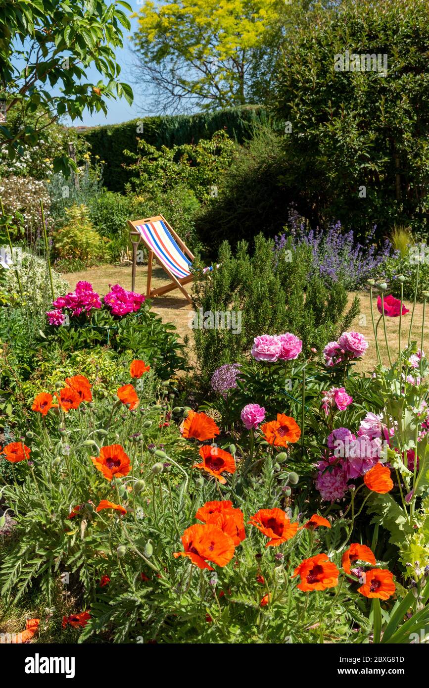North Hampshire, England, UK. May 2020. An attractive English country garden and a deckchair in early summer. Hampshire, England UK. Stock Photo