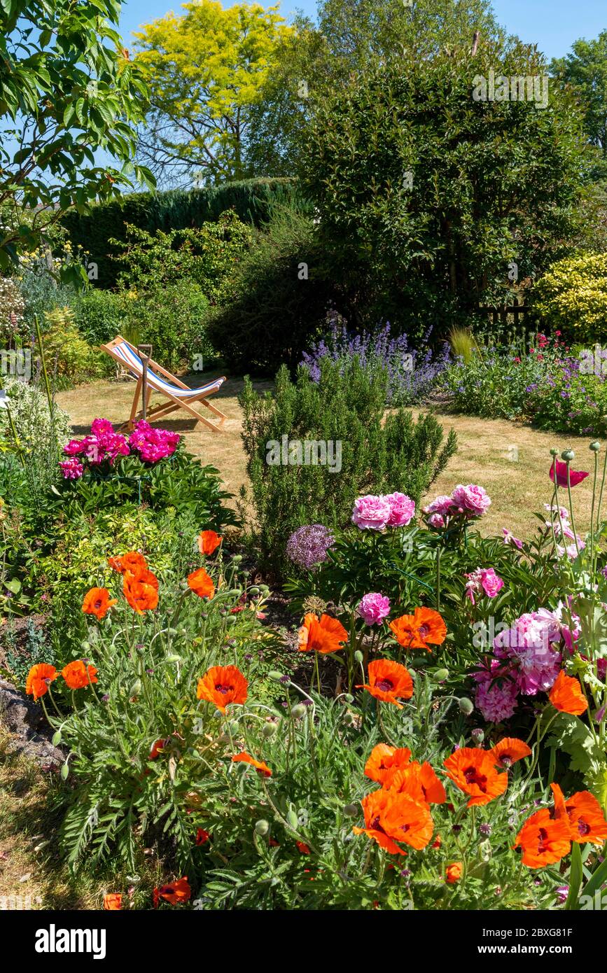 North Hampshire, England, UK. May 2020. An attractive English country garden and a deckchair in early summer. Hampshire, England UK. Stock Photo