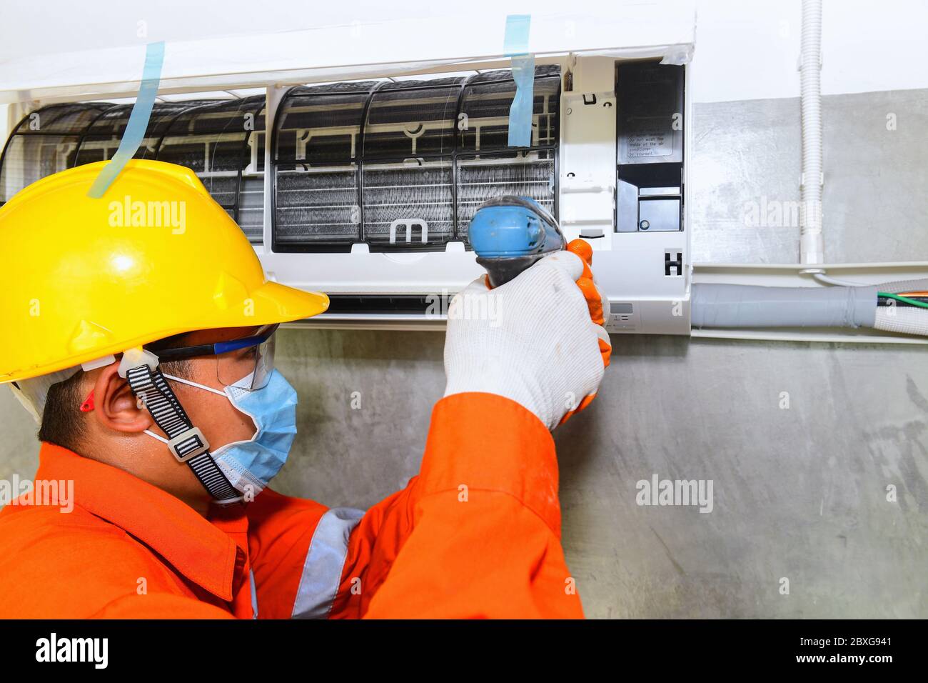 Technician installing air conditioner on the wall, Thailand Stock Photo