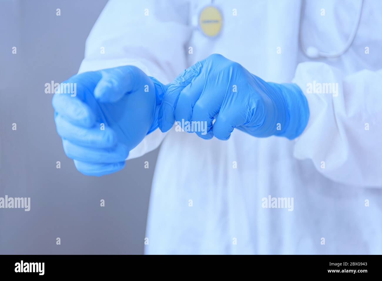 Doctor wearing PPE putting on surgical gloves, Thailand Stock Photo Alamy