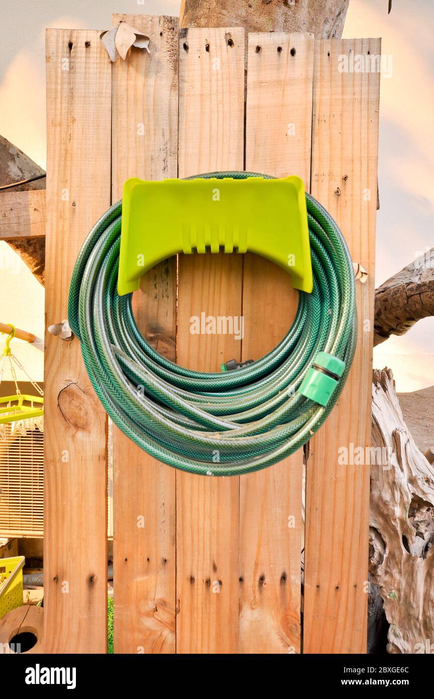 Hoses are rolled up in storage which in garden Stock Photo