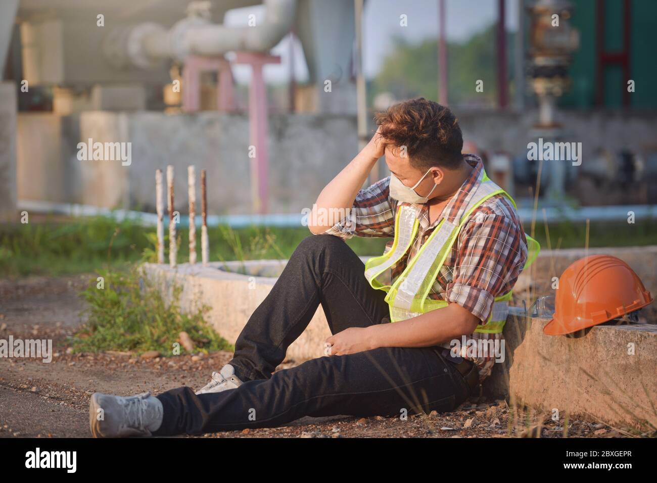 Construction worker wearing a face mask taking a break, Thailand Stock Photo