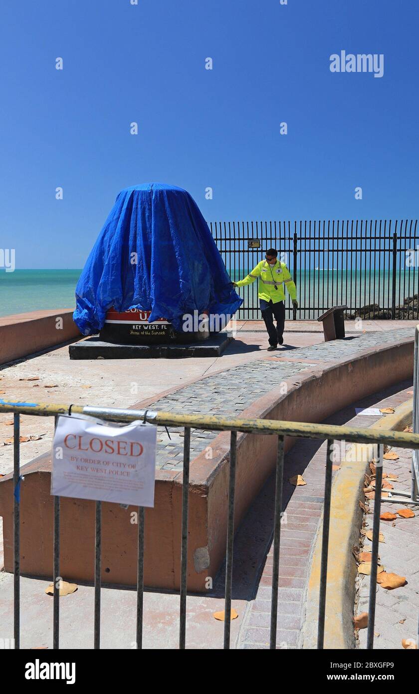 Key West, FL, 3/21/2020: Municipal employee is closing the southernmost point of the USA marker.  The closure happened due to the coronavirus pandemic Stock Photo