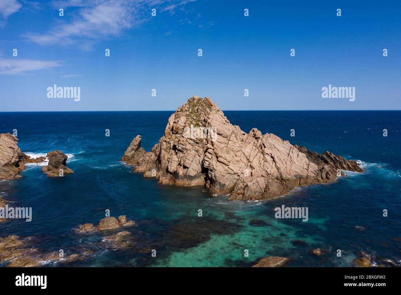 Sugarloaf Rock is a large, natural granite island in the Indian Ocean just off the coast approximately 2 kilometres south of Cape Naturaliste near Bus Stock Photo