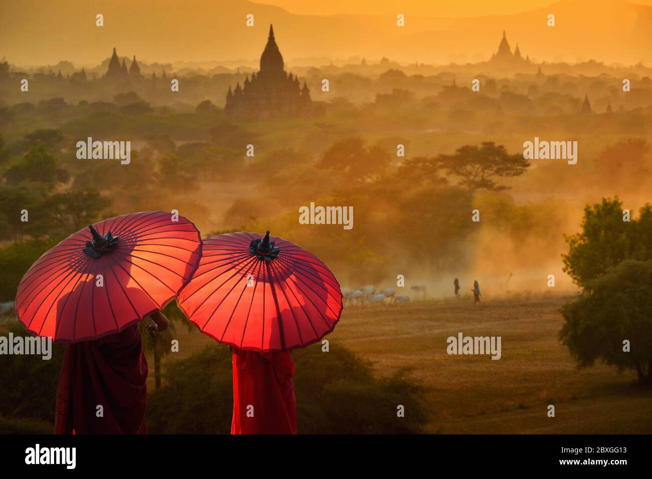 Rear view of two novice monks with parasols looking at view, Bayan, Mandalay, Myanmar Stock Photo