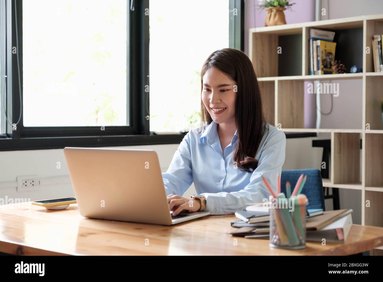 Portrait of young woman using laptop, she is working on laptop computer ...