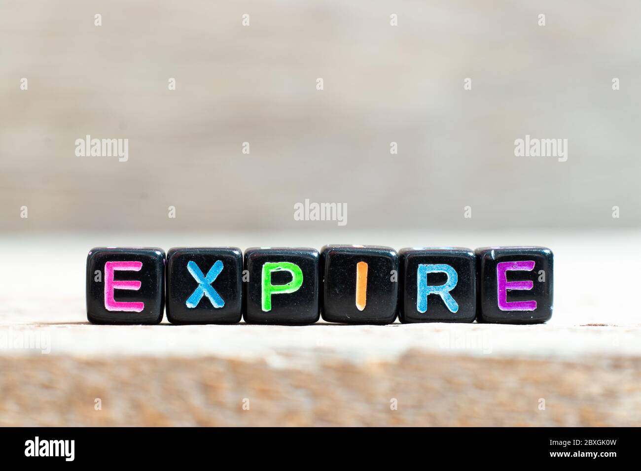 Black bead with color letter in word expire on wood background Stock Photo