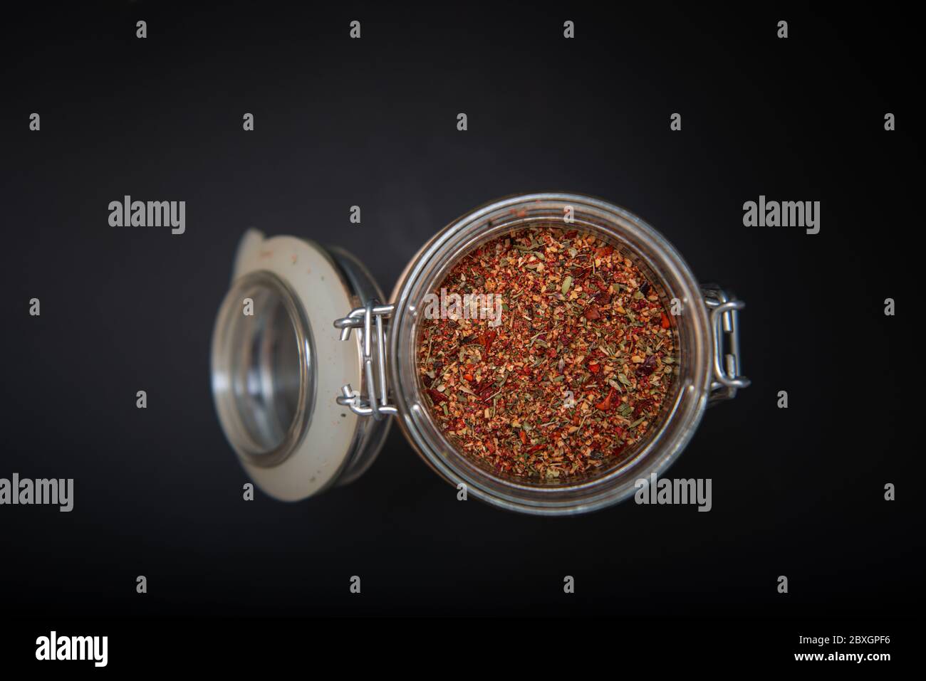 Indian spices in an open jar on a black table with copy space Stock Photo