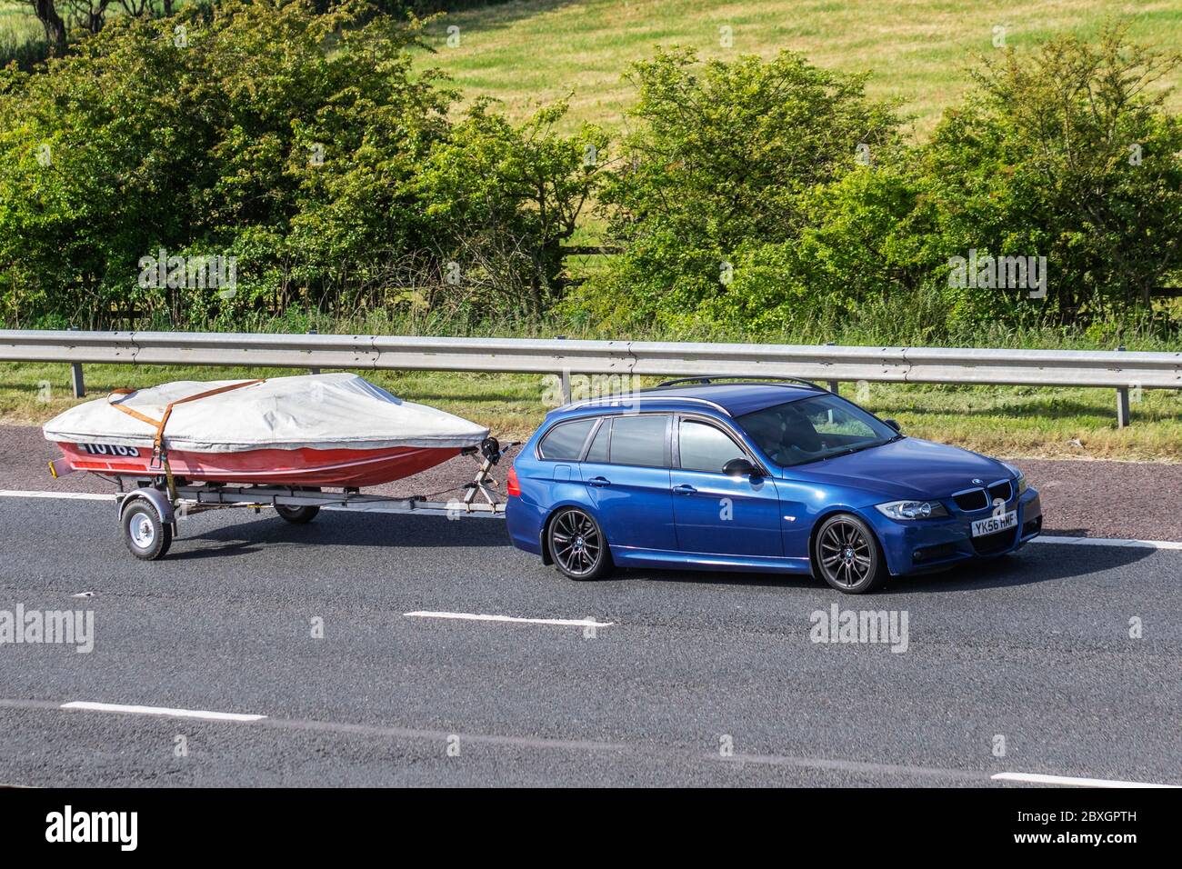 2006 blue BMW 320D M Sport Touring towing boat on trailer; Vehicular ...