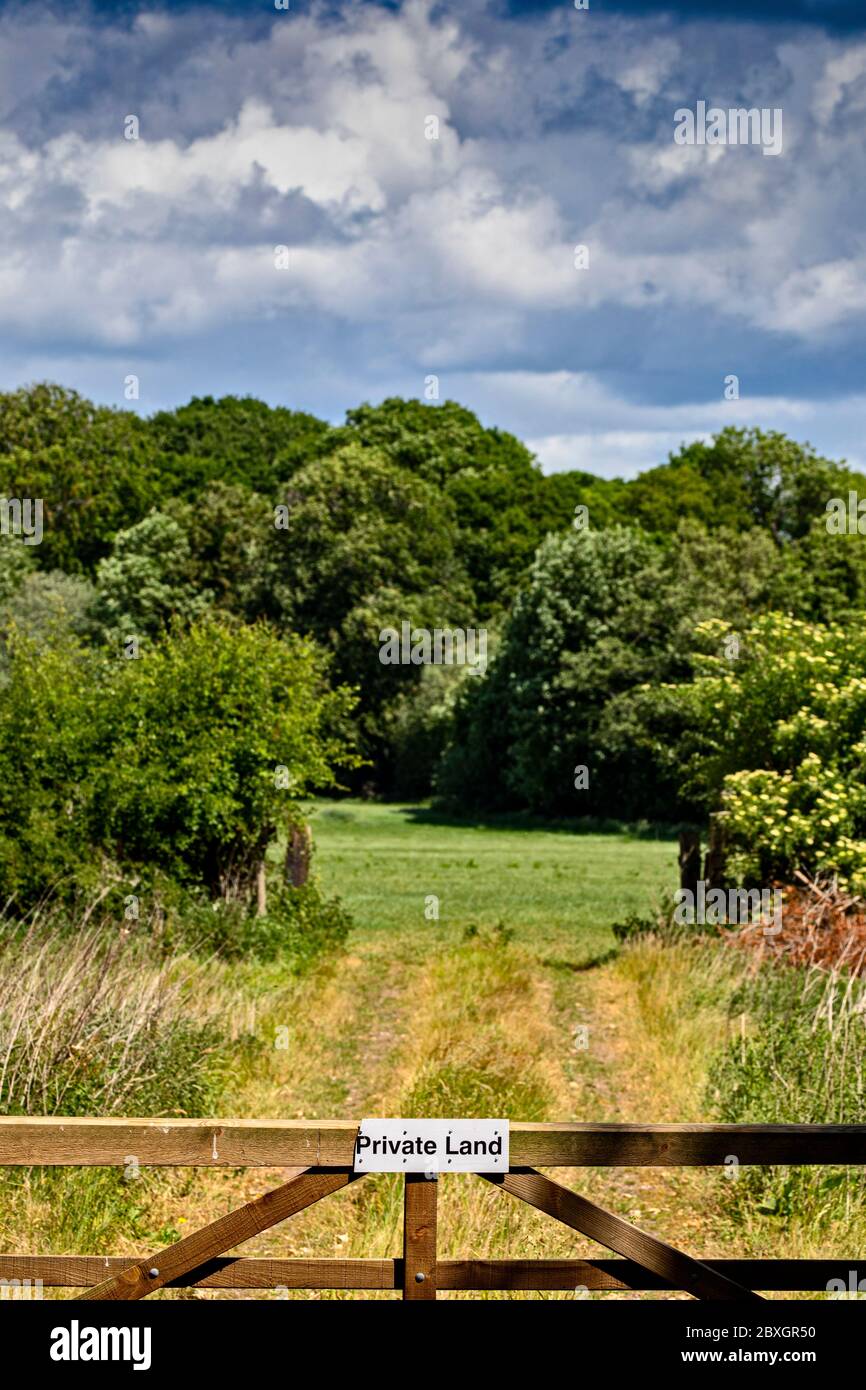 Countryside view over farm gate with private land sign in Cheshire UK Stock Photo