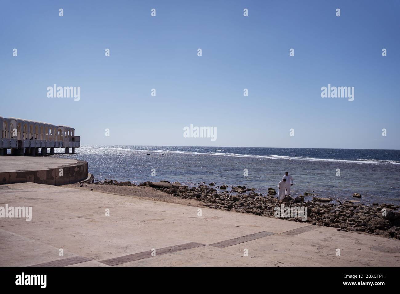 Jeddah / Saudi Arabia - January 20, 2020: Two Muslim men in white traditional clothes near beautiful Mosque near the sea Stock Photo