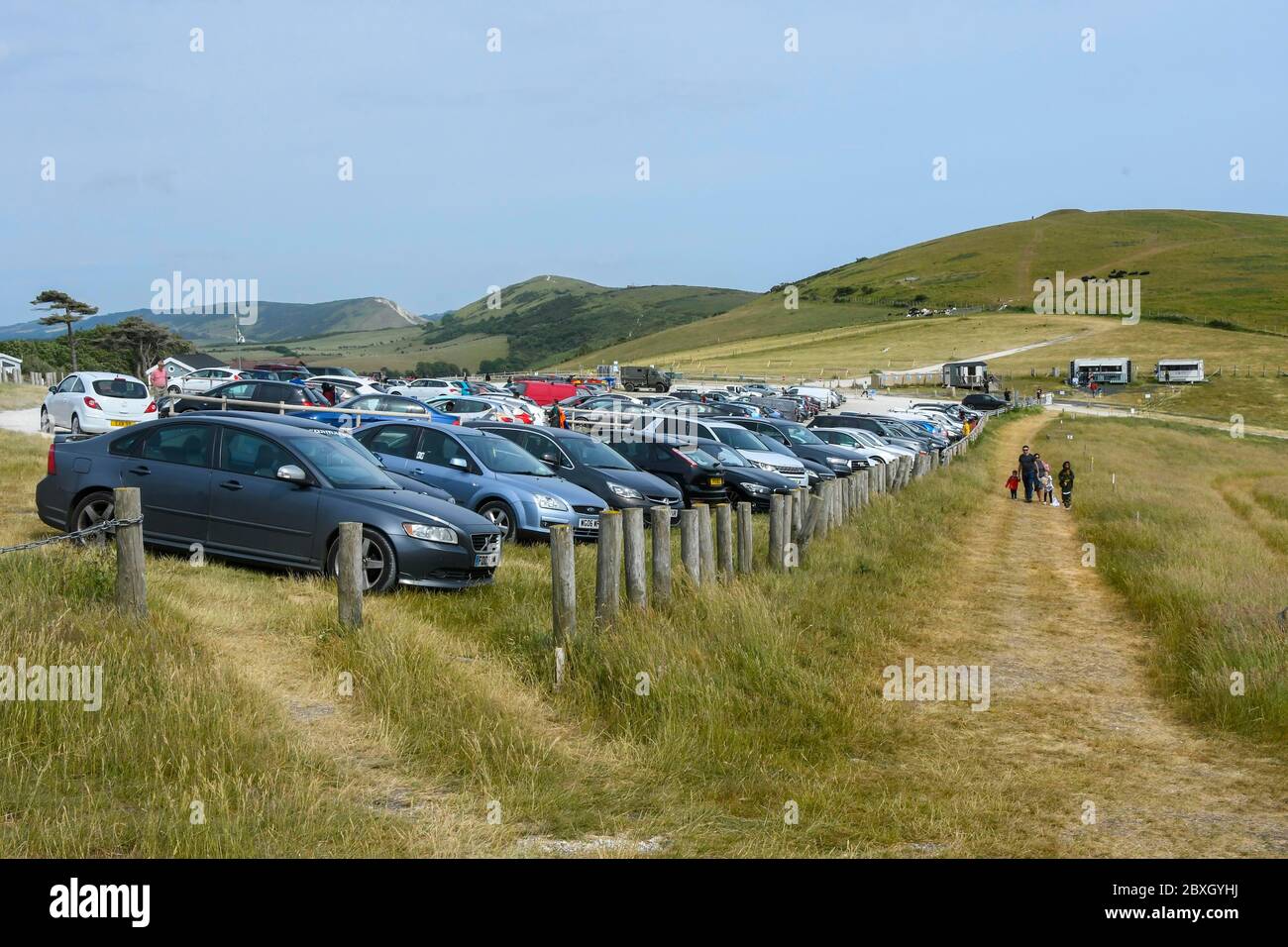 Durdle Door, Lulworth, Dorset, UK.  7th June 2020.  UK Weather. Visitor numbers are greatly reduced from the previous weekend at Durdle Door at Lulworth in Dorset due to the lower temperatures and hazy sunshine.  The  main car park is busy but none of the overflow car parking fields have been needed to be opened.  Picture Credit: Graham Hunt/Alamy Live News Stock Photo