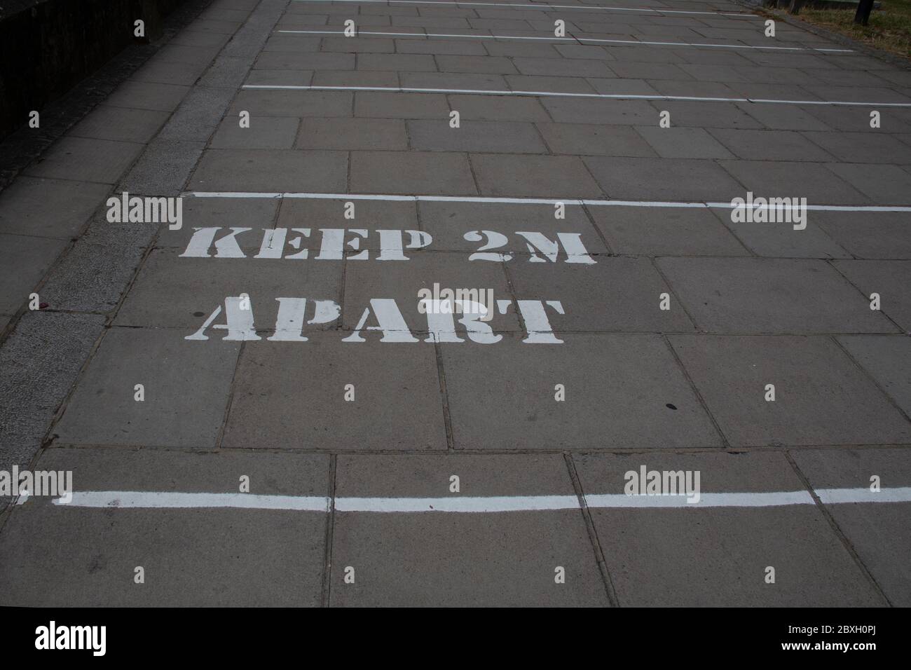 Sign on the pavement reminding people to stay two metres apart during the corona pandemic, Hammersmith West London UK Stock Photo