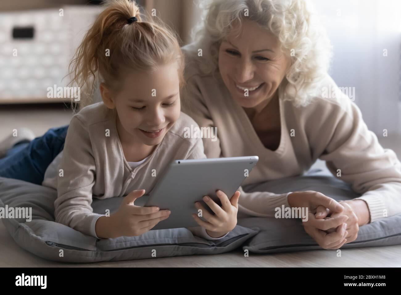 Happy little girl have fun using tablet with grandmother Stock Photo ...