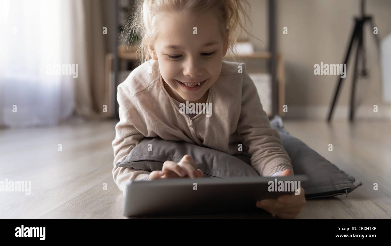 Happy little girl using modern tablet at home Stock Photo - Alamy