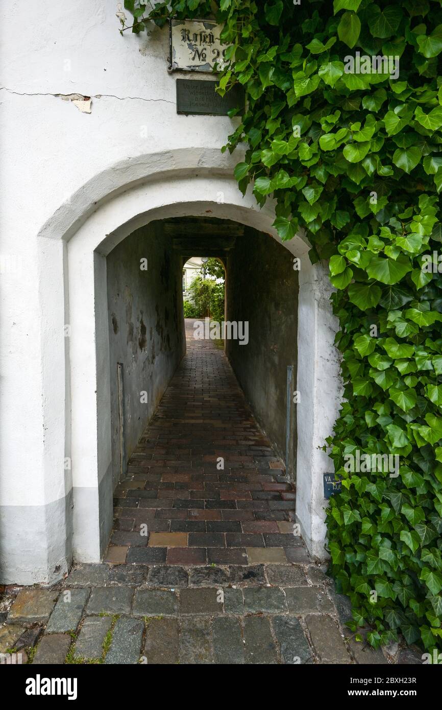 Narrow entrance tunnel to a small residential alley, typical tourist destination in the medieval old town of Luebeck, Germany, selected focus Stock Photo