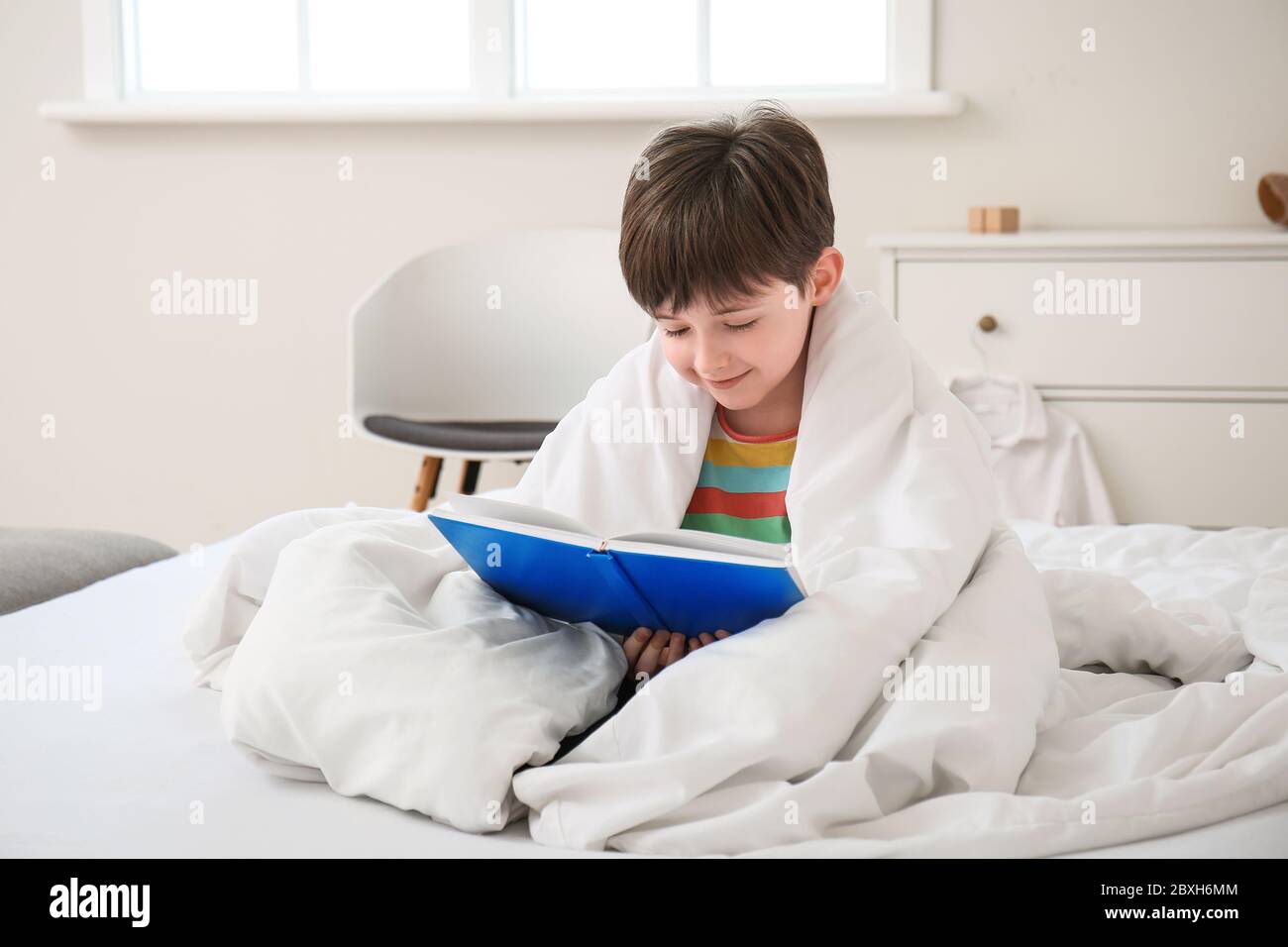 Morning Of Little Boy Reading Book In Bedroom Stock Photo Alamy