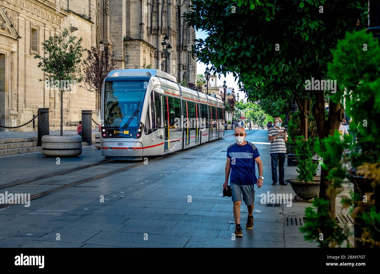 Seville, Spain; June 7, 2020: Selective focus on the tramway with blurry pedestrians. Stock Photo