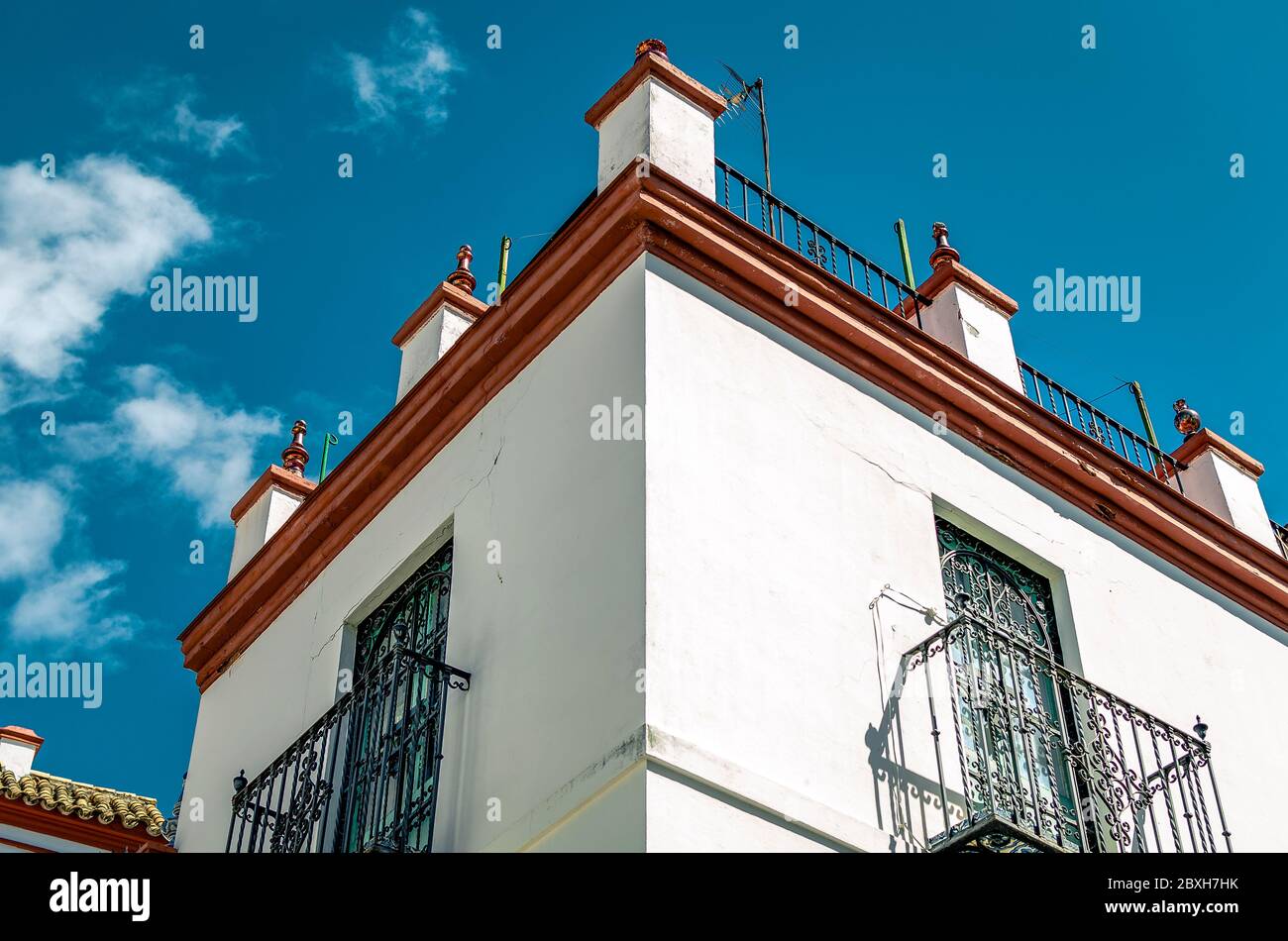 Traditional facade of a white house with twisted forged balconies in Seville, Andalusia Spain Stock Photo