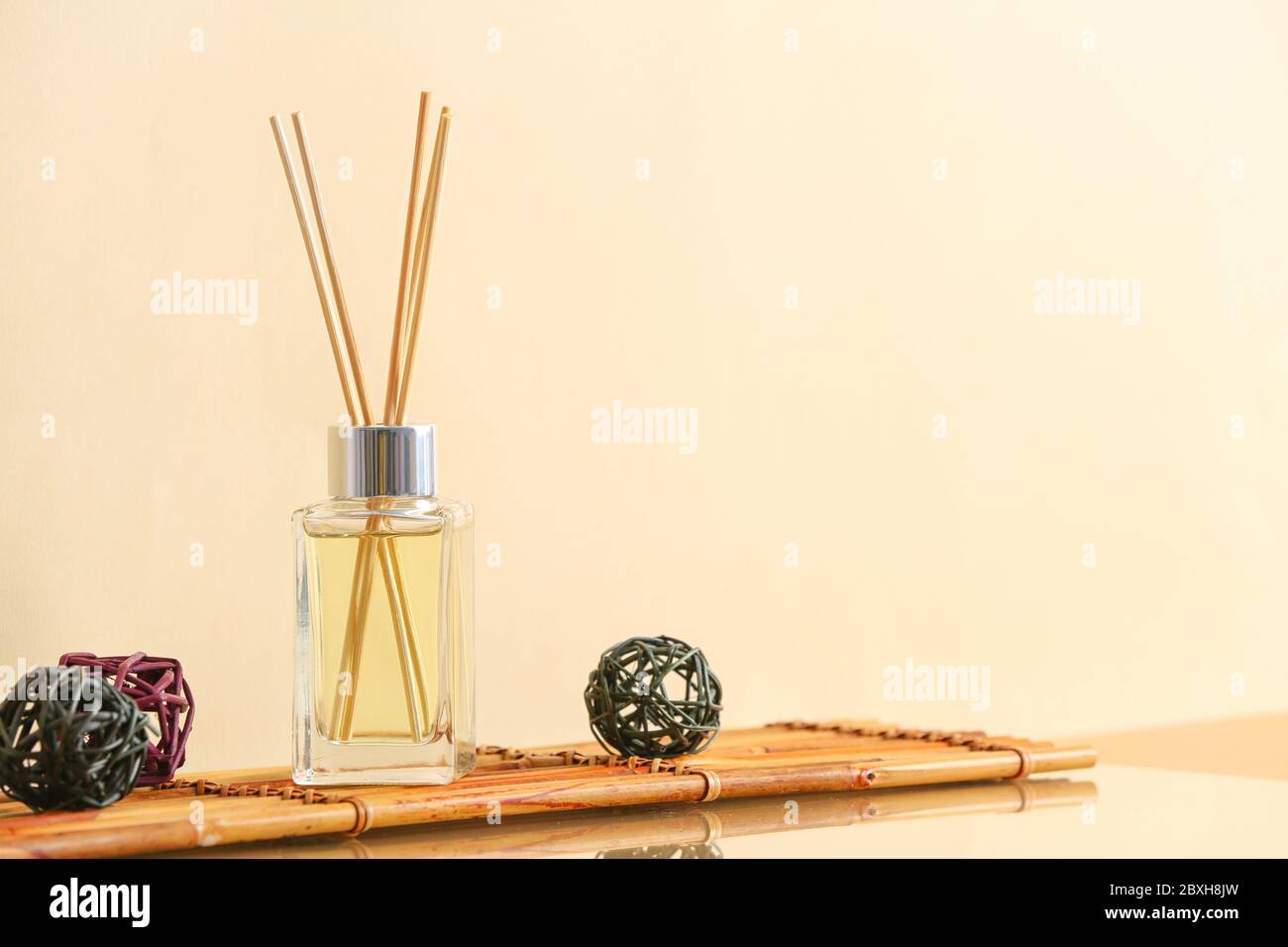 Reed diffuser on table against color background Stock Photo