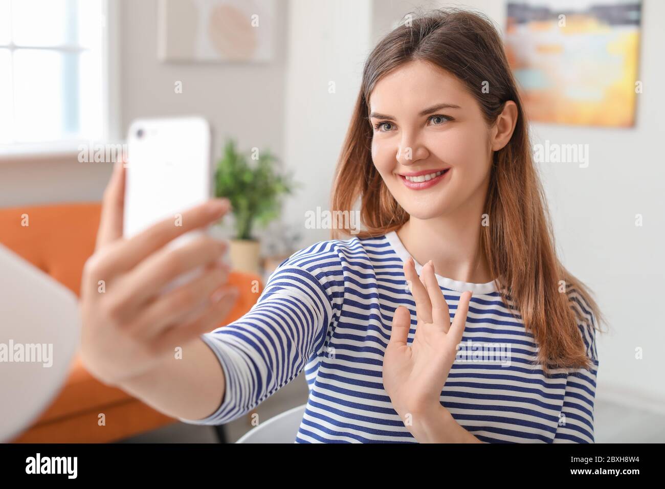Beautiful young woman taking selfie at home Stock Photo - Alamy