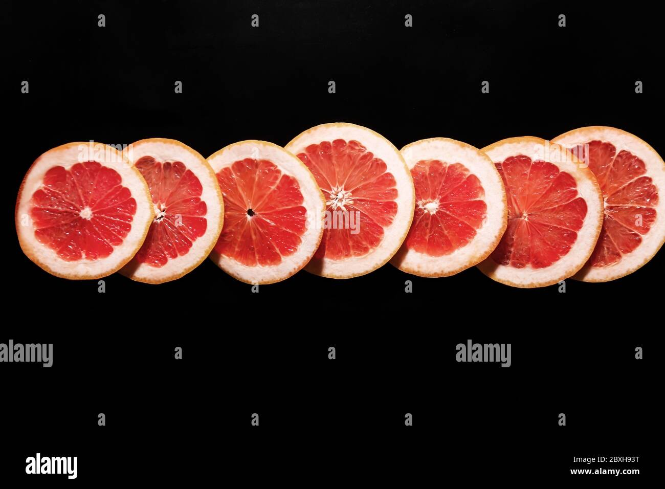 Fresh sliced grapefruit on dark background Stock Photo
