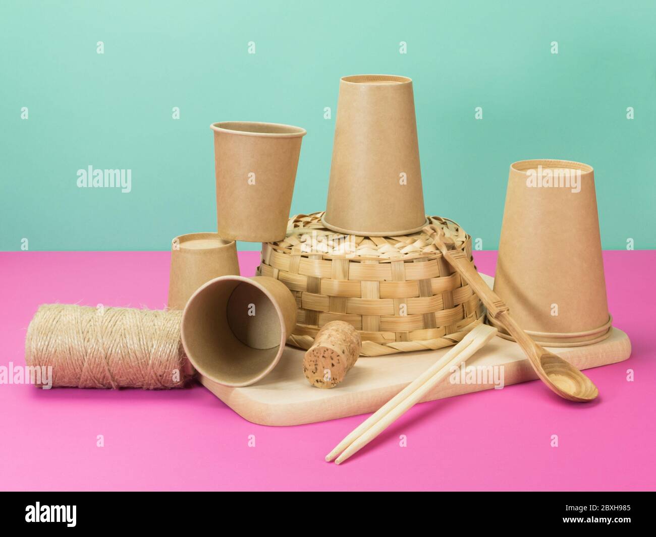 Environmental crockery and other household items from natural materials. Beige pink and turquoise background. Stock Photo