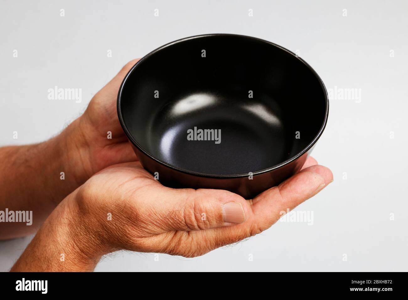 Man holds an empty bowl in his hands. Help needed Stock Photo