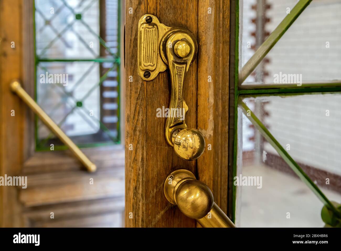 Old copper door handle and lock on the door of station of the M1 metro line of Budapest.With its opening in 1896,it was the first underground railway Stock Photo