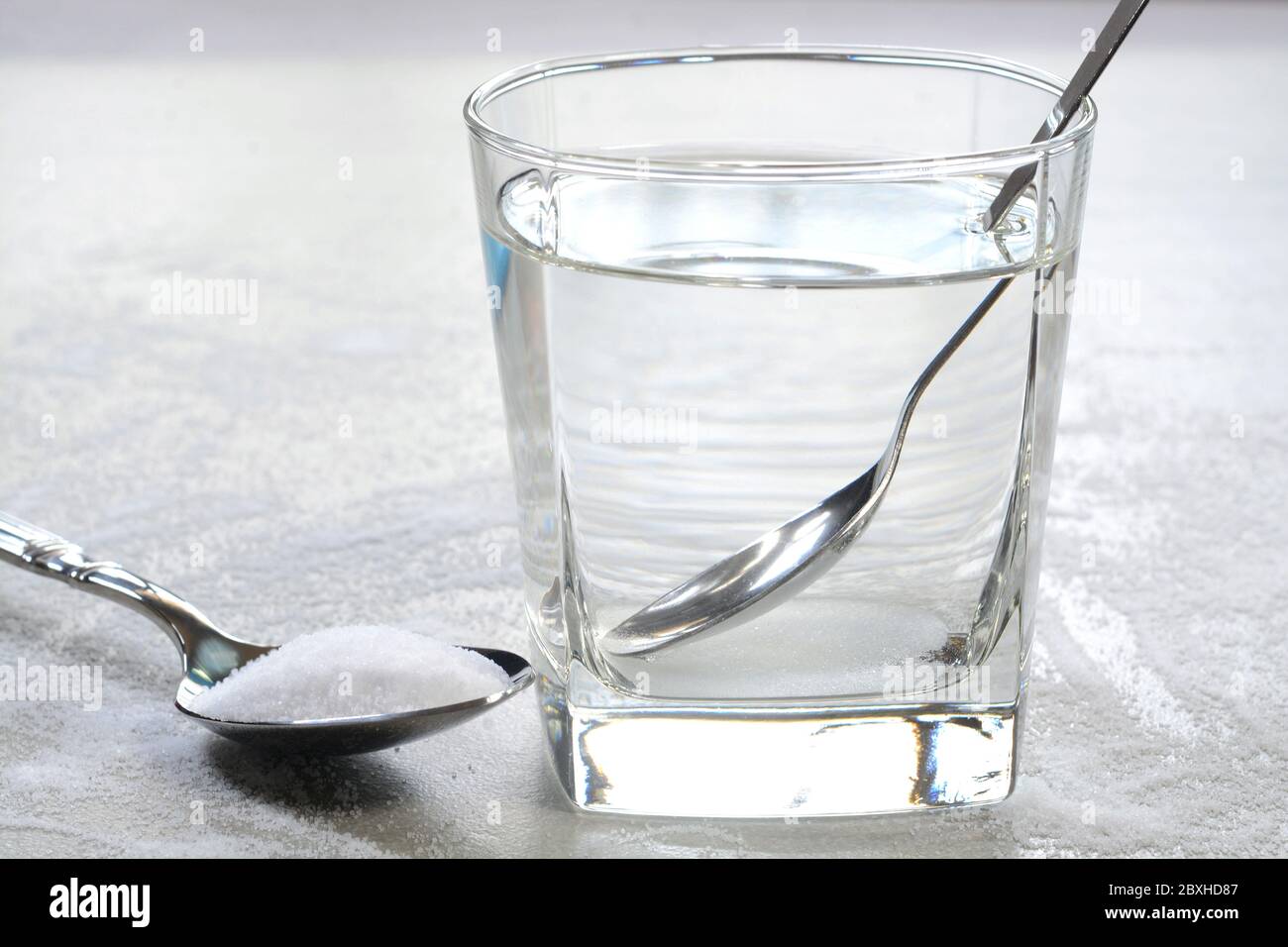 Salt water in a glass cup and salt in a teaspoon Stock Photo Alamy