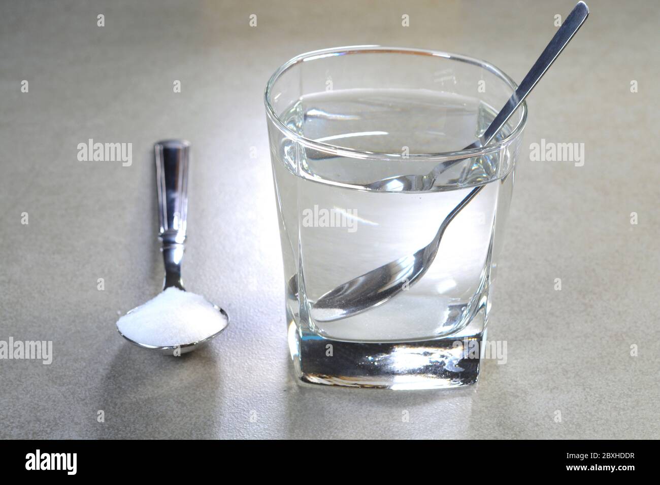 Salt water in a glass cup and salt in a teaspoon Stock Photo Alamy