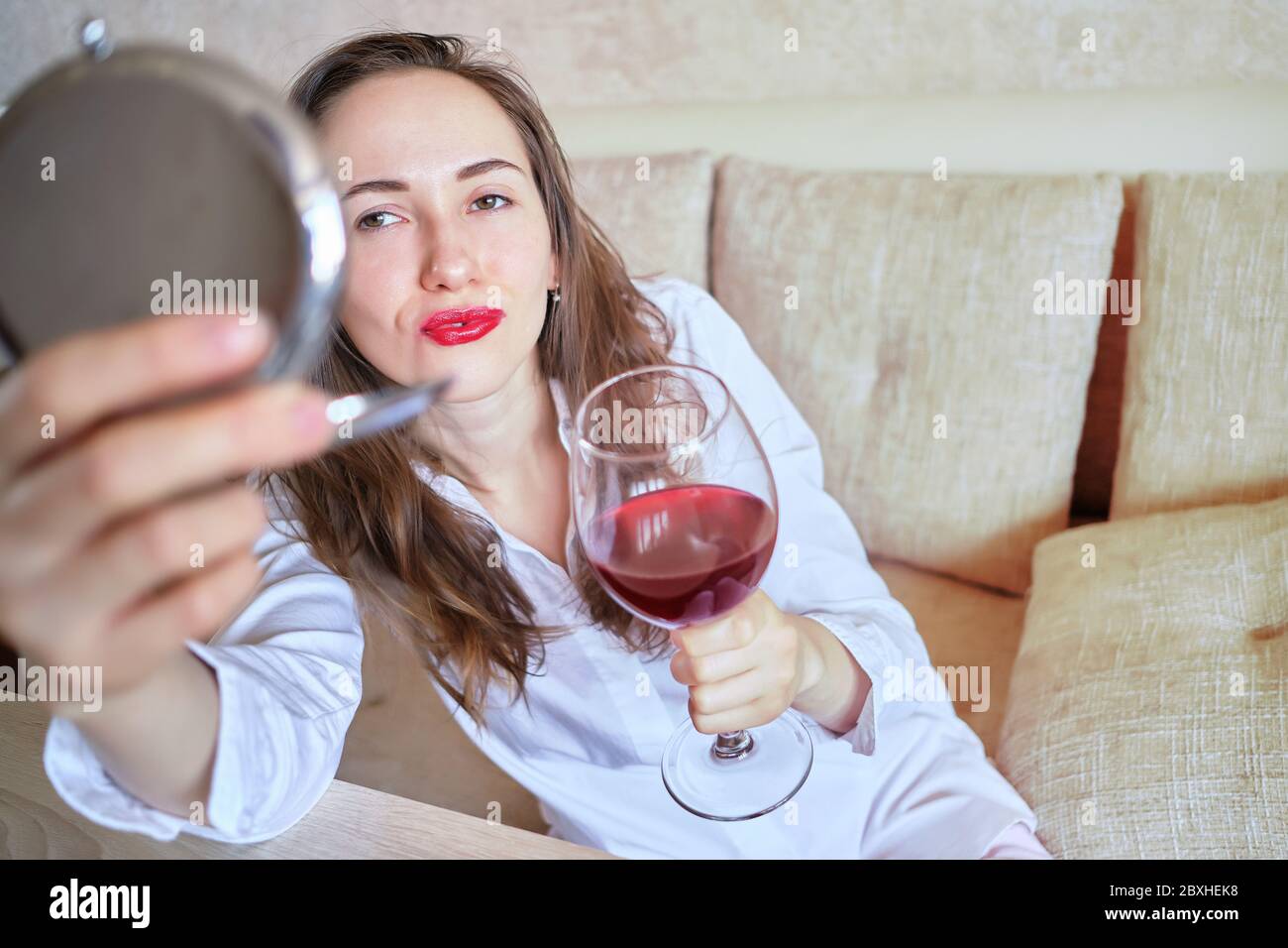 Girl With A Bad Appearance, In A Bra And Mask For Sleeping, Holds A Bottle  Of Alcohol And Looks At It. Stock Photo, Picture and Royalty Free Image.  Image 92392163.