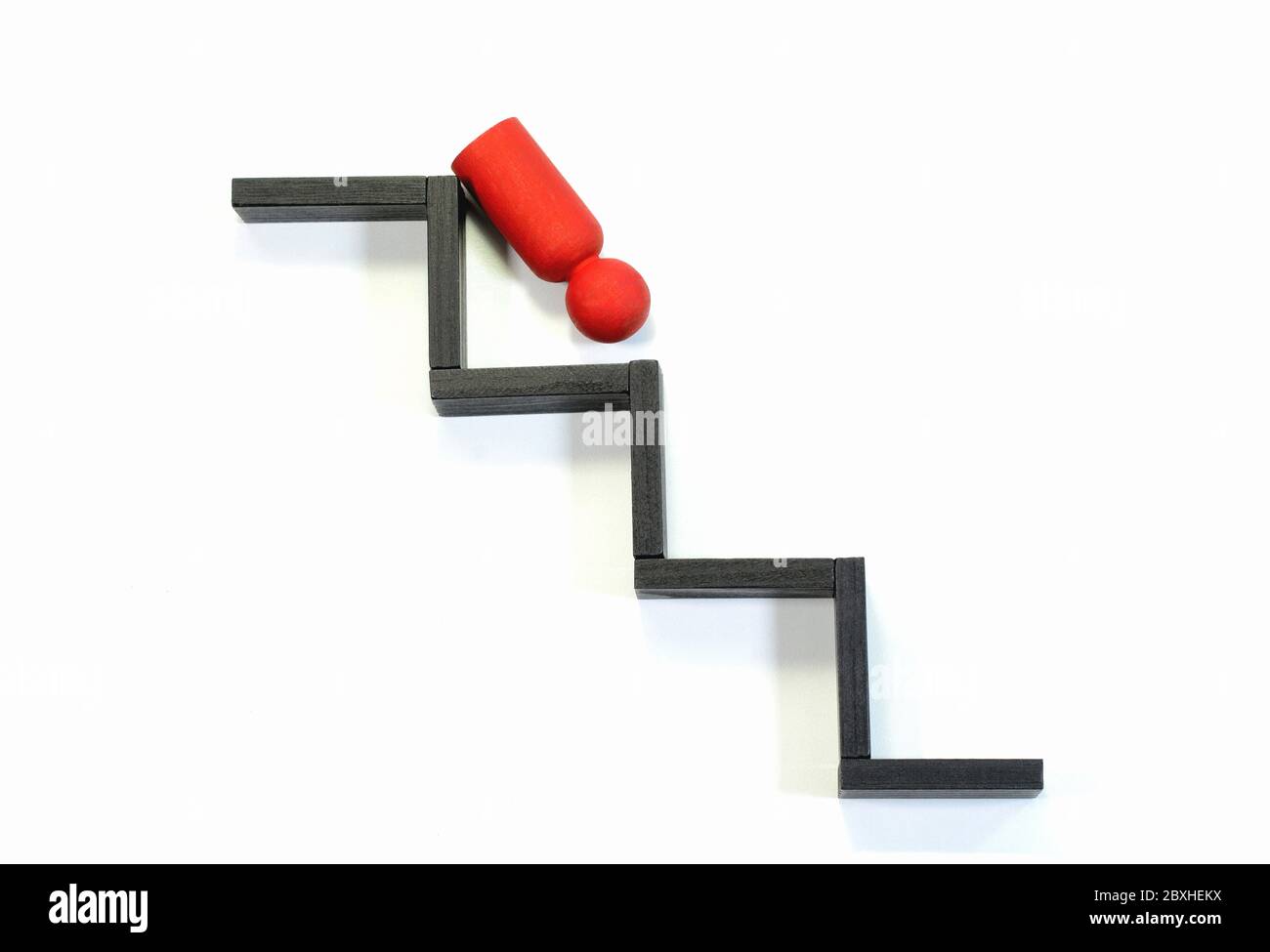Wooden figurine falling from the steps. Concept of leadership failure. Stock Photo