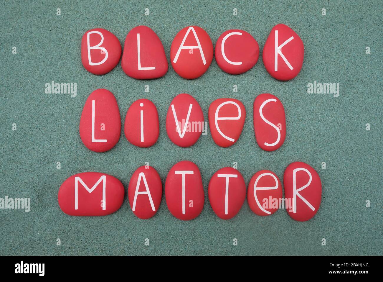 Black Lives Matter, slogan and social issue against violence and systemic racism towards black people composed with red colored stone letters Stock Photo