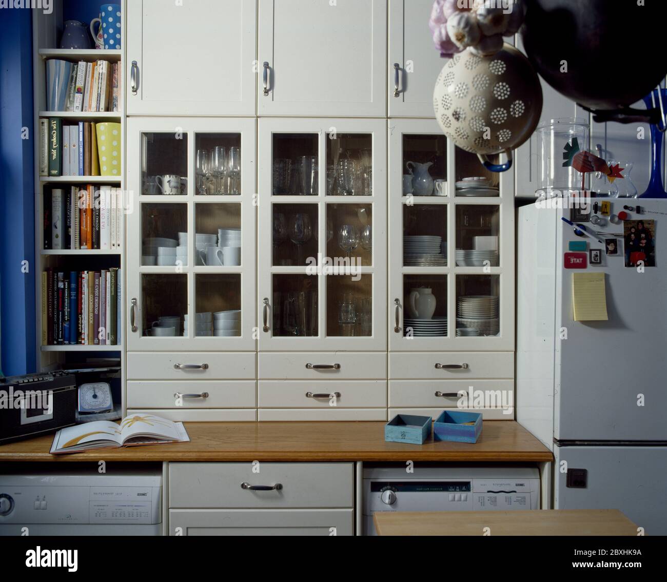 Closeup of kitchen storage with glazed cupboard doors and small drawers Stock Photo