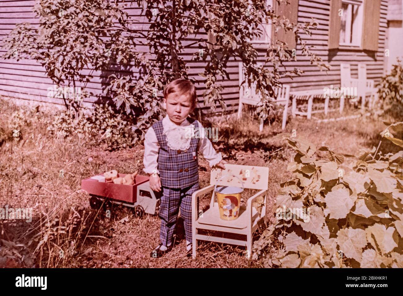 Latvia - CIRCA 1969s: Portrait of boy playing in garden. Vintage coloured photography Stock Photo