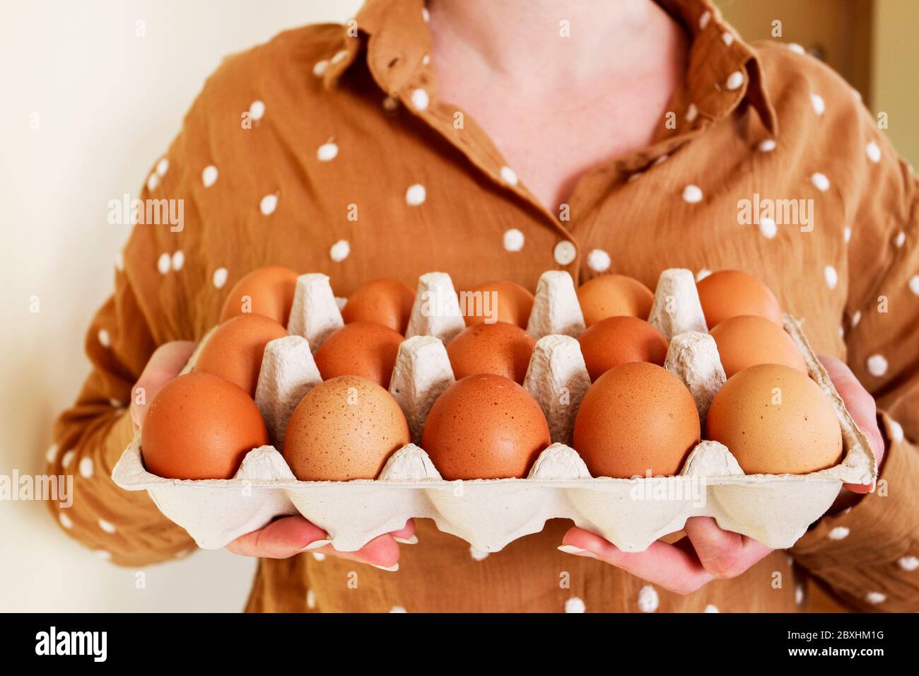 Woman is holding a paper box with eggs. Cooking time Stock Photo